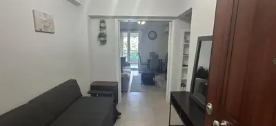 a living room with a couch and a room with a mirror at Glyfada31 near center in Athens