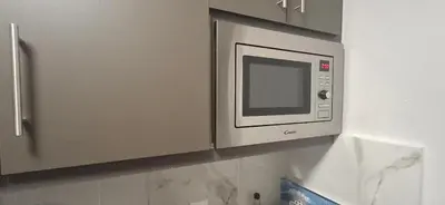 a microwave oven on a wall in a kitchen at Glyfada31 near center in Athens