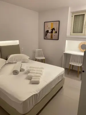 a white bedroom with a bed with towels on it at Erexthion Diony1 Apartment in Athens