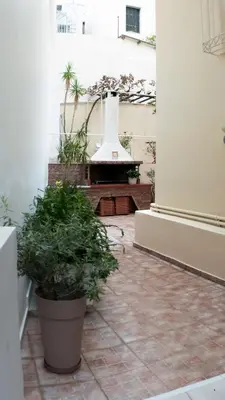 a courtyard with two potted plants in a building at Erexthion Diony1 Apartment in Athens