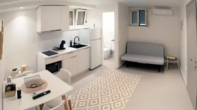 a white kitchen with a table and a chair at Erexthion Diony1 Apartment in Athens