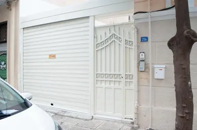 a white garage door on the side of a building at Erexthion Diony1 Apartment in Athens