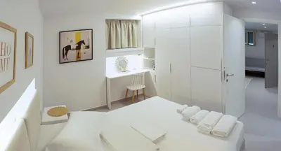 a white bathroom with a shower and a white couch at Erexthion Diony1 Apartment in Athens
