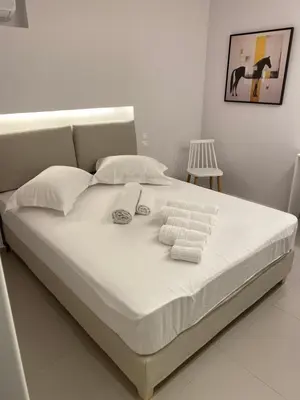 a bed with white sheets and folded towels on it at Erexthion Diony1 Apartment in Athens