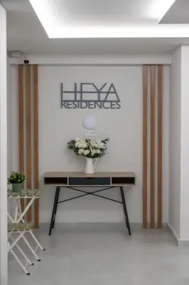 a table with a vase of flowers on a wall at Shiny Santorini Apartment in Piraeus