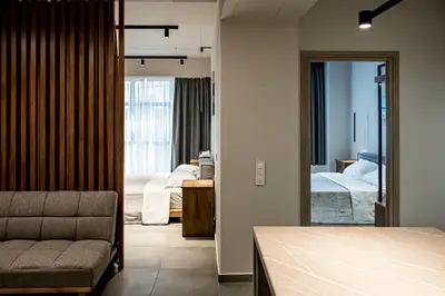 a bedroom with a bed and a living room with a couch at Shiny Santorini Apartment in Piraeus