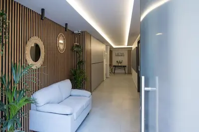 a living room with a white couch in a hallway at Shiny Santorini Apartment in Piraeus