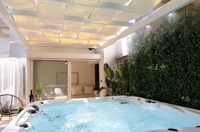 a jacuzzi tub in a backyard with a roof at Coastal Charm by Neuvel in Athens
