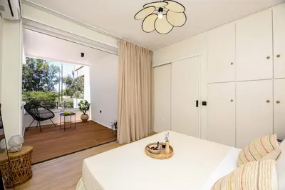 a bedroom with a bed and a living room at Coastal Charm by Neuvel in Athens