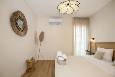 a white bedroom with a large bed and a mirror at Coastal Charm by Neuvel in Athens