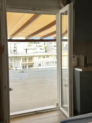 an open sliding glass door with a view of a building at Rooftop in Psyrri- 360 Athens view in Athens