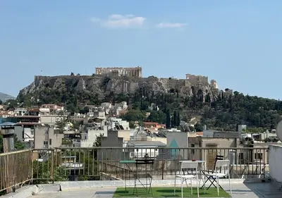 a view of a city with chairs on a roof at Rooftop in Psyrri- 360 Athens view in Athens