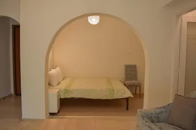a bedroom with an archway with a bed and a chair at Sofia's Urban Flat - Near Tram in Athens