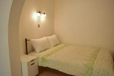 a small bedroom with a bed and a night stand at Sofia's Urban Flat - Near Tram in Athens