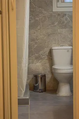 a bathroom with a toilet and a trash can at Sofia's Urban Flat - Near Tram in Athens