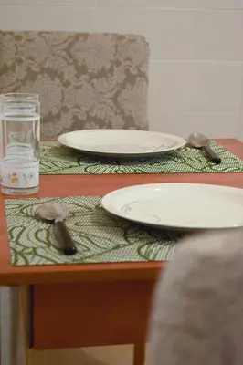 a table with two plates and a glass of water at Sofia's Urban Flat - Near Tram in Athens