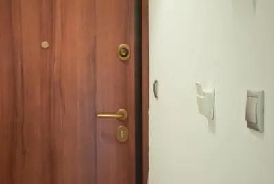 a wooden door with a handle next to a white wall at Sofia's Urban Flat - Near Tram in Athens
