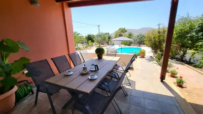 a wooden table and chairs on a patio at Luxury villa Espera Lagonisi with private pool in Kalívia Thorikoú