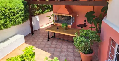 an outdoor patio with a table and a fireplace at Luxury villa Espera Lagonisi with private pool in Kalívia Thorikoú