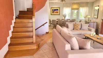 a living room with a couch and a staircase at Luxury villa Espera Lagonisi with private pool in Kalívia Thorikoú