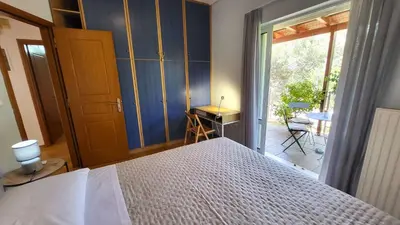 a bedroom with a bed and a sliding glass door at Luxury villa Espera Lagonisi with private pool in Kalívia Thorikoú