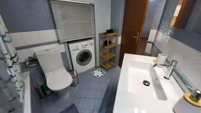 a bathroom with a toilet and a washing machine at Luxury villa Espera Lagonisi with private pool in Kalívia Thorikoú