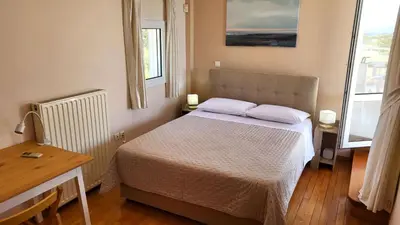 a small bedroom with a bed and two windows at Luxury villa Espera Lagonisi with private pool in Kalívia Thorikoú