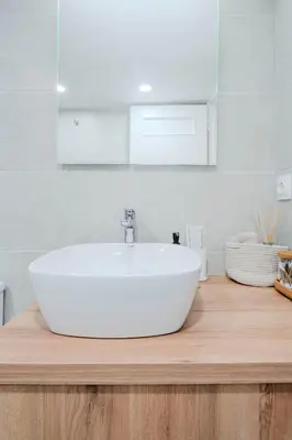 a white sink on a wooden counter in a bathroom at Sefis apartment in Athens