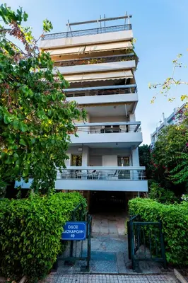 a tall white building with a sign in front of it at Sefis apartment in Athens
