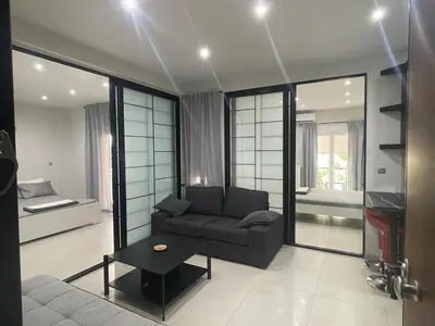 a living room with a couch and a bed at Chris375flat-ParkOperaOnasioRea in Athens