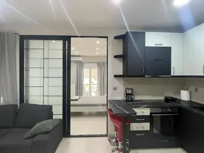 a living room with a couch and a kitchen at Chris375flat-ParkOperaOnasioRea in Athens