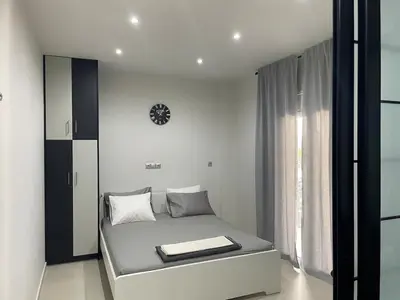 a bedroom with a bed with a clock on the wall at Chris375flat-ParkOperaOnasioRea in Athens