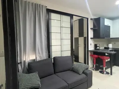 a living room with a couch and a kitchen at Chris375flat-ParkOperaOnasioRea in Athens