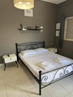 a bedroom with a large bed with white sheets at Sparrow s nest in Koropíon