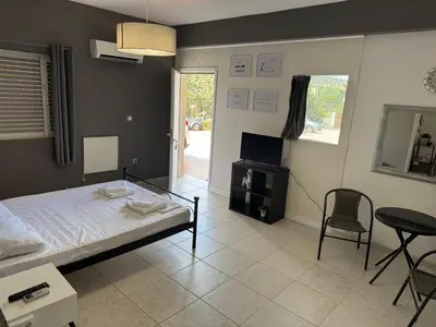 a bedroom with a bed and a table and chairs at Sparrow s nest in Koropíon