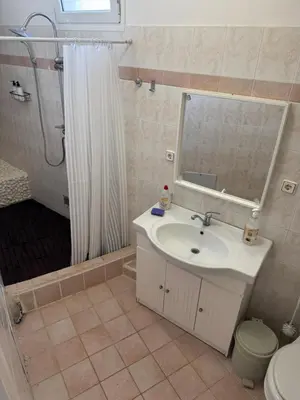 a bathroom with a sink and a shower with a mirror at Sparrow s nest in Koropíon