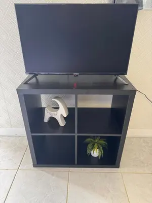 a black entertainment center with a tv on top at Sparrow s nest in Koropíon