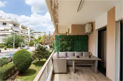 a balcony with a couch and a table on a building at Glyfada Lux Olive Suites - Aura & Glow in Athens