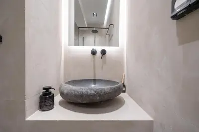 a bathroom with a large stone sink on a counter at Glyfada Lux Olive Suites - Aura & Glow in Athens