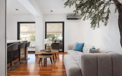 a living room with a couch and a table at Glyfada Lux Olive Suites - Aura & Glow in Athens