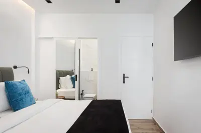 a bedroom with a white bed and a mirror at Glyfada Lux Olive Suites - Aura & Glow in Athens