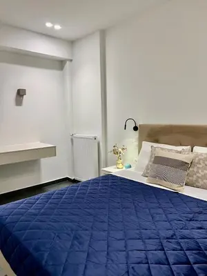 a bedroom with a bed with a blue blanket at Home in Piraeus in Piraeus
