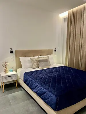 a bedroom with a large bed with a blue blanket at Home in Piraeus in Piraeus