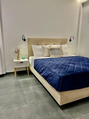 a bedroom with a large bed with a blue comforter at Home in Piraeus in Piraeus