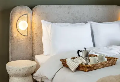 a bed with a tray of coffee cups and a table at Pause In Athens in Athens