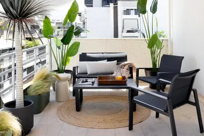 a table and chairs on a balcony with plants at Pause In Athens in Athens