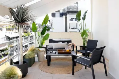 a balcony with a table and chairs and plants at Pause In Athens in Athens
