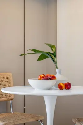 a white table with a bowl of fruit and a plant at Pause In Athens in Athens