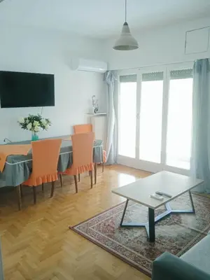 a living room with a table with chairs at \u96c5\u5178\u6d77\u6ee8\u516c\u5bd3 in Athens