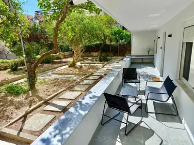 a row of chairs on a patio with trees at Christina's Home in Athens